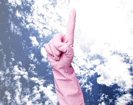 pink cleaning gloves pointing up against a blu sky background