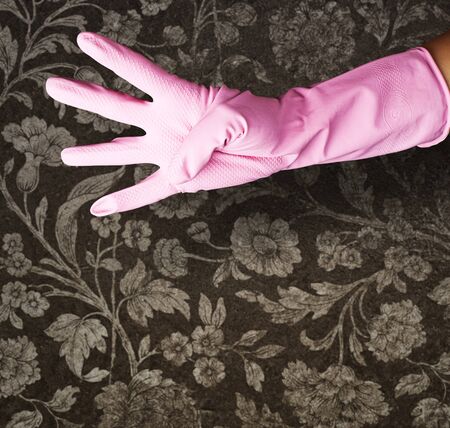 pink gloves of maid gesturing number four against a vintage wall