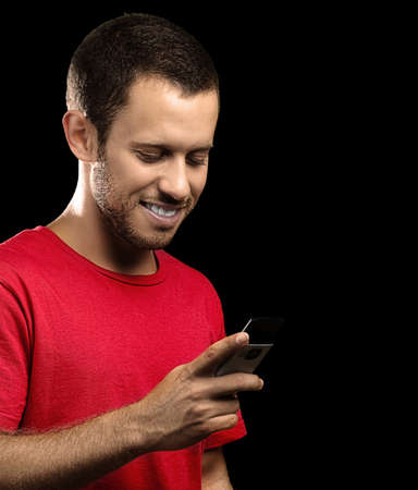 young man typing on mobile phone on black background