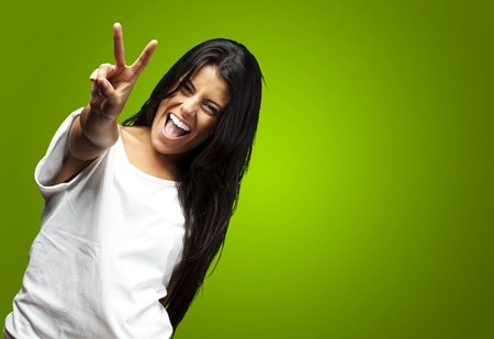 portrait of young woman gesturing good against a green backgroundの写真素材