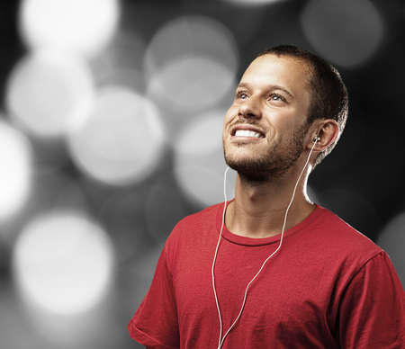 young man with white shirt against a city lights backgroundの写真素材
