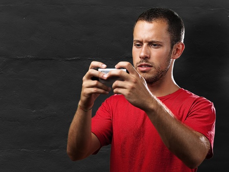 young man typing on mobile phone against a grunge wallの写真素材
