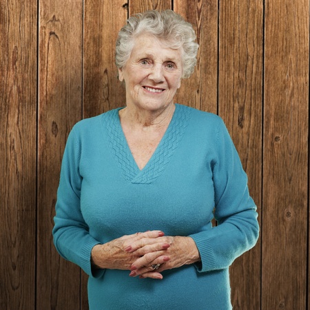 portrait of senior woman standing against a wooden wallの写真素材