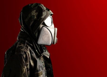 portrait of soldier with gas mask against a red background