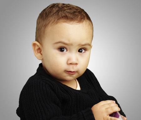 handsome young boy posing against a grey backgroundの写真素材