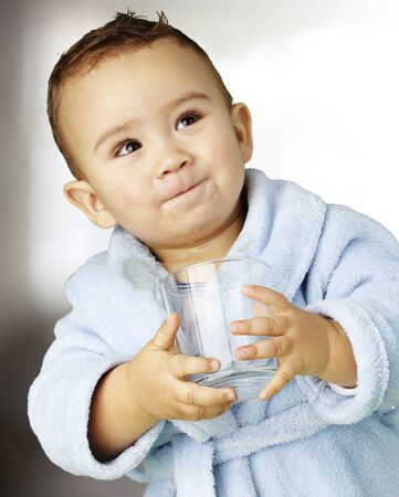 boy wearing a bathrobe and holding a glass, indoorの写真素材