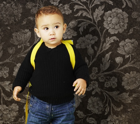 young boy with a backpack against a vintage backgroundの写真素材