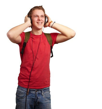 portrait of cheerful young student listening music with headphones over whiteの写真素材