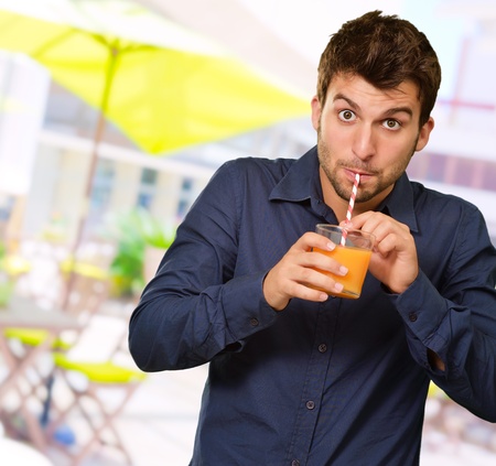 Man Sipping Juice Through Straw, Outdoorの写真素材