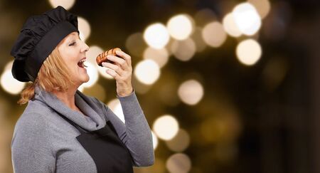 Portrait Of A Woman While Eating Pastry, Outdoorの写真素材
