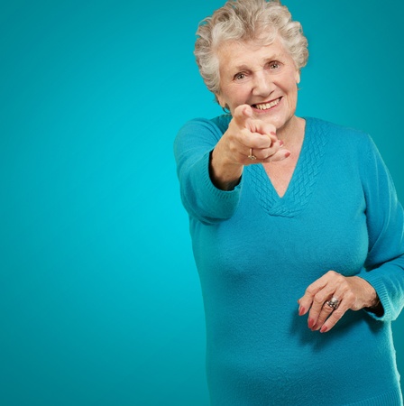 Portrait Of Woman Pointing Her Finger On Turquoise Backgroundの写真素材