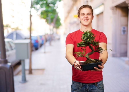 portrait of a young man holding a pot, outdoor