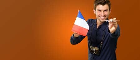 Man Holding A Miniature Airplane And France Flag On Coloured Backgroundの写真素材