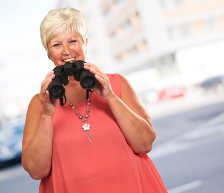 A Senior Woman Holding Binoculars, Outdoorの写真素材