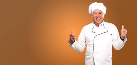 Portrait Of A Chef Cook With Hand Sign On Yellow Backgroundの写真素材