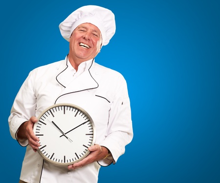 Potrait Of Chef Showing Watch On Blue Backgroundの写真素材