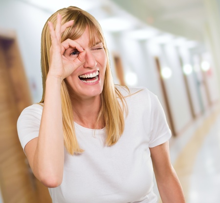 Happy Woman Looking Through Finger in a passagewayの写真素材