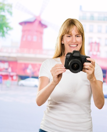 Happy Young Woman Looking At Camera against a red building as a background, outdoorの写真素材