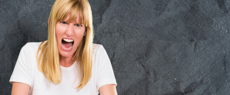 Portrait Of Angry Woman against a dark concrete backgroundの写真素材