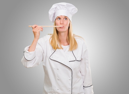 Female Chef Tasting Food against a grey backgroundの写真素材
