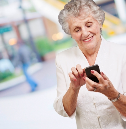 Senior woman with mobile phone, outdoorの写真素材
