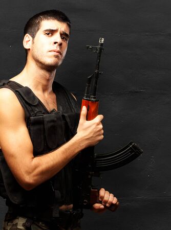 Portrait Of Soldier Holding Gun against a grunge background