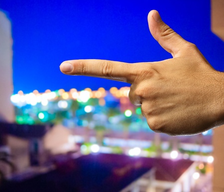 Human Hand pointing with finger isolated on a city by night backgroundの写真素材
