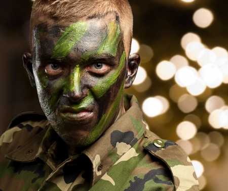 Close Up Of Angry Soldier against a background of shiny lightsの写真素材