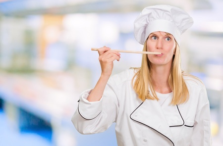 Female Chef Tasting Food against an abstract backgroundの写真素材
