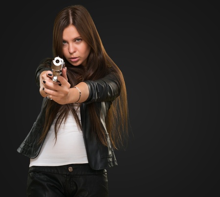 Portrait Of A Woman Holding Gun against a black background
