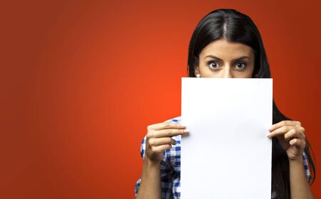 Woman Holding Paper against a red backgroundの写真素材