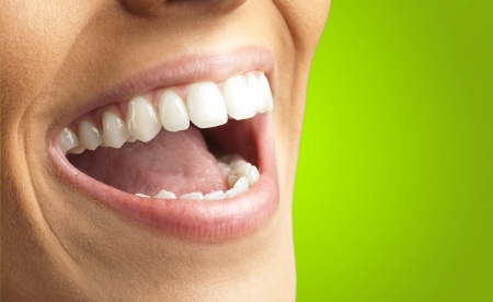 Close Up Of Smiling Teeth against a green background