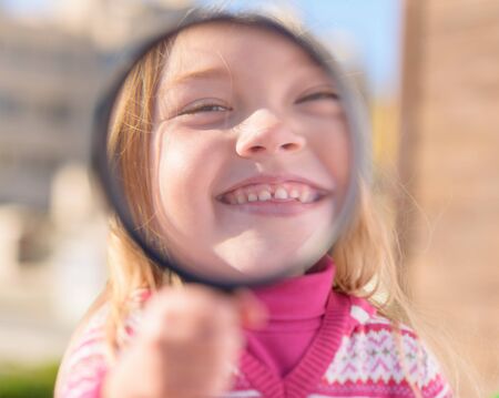 Portrait Of Girl Looking Through Magnifying Glass, Outdoors
の写真素材