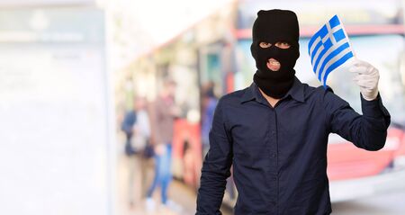 Portrait of a man wearing mask holding a flag, outdoorの写真素材