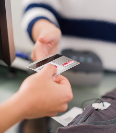 Close-up Of Woman's Hand Paying Bill With Credit Card