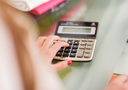 Close-up Of Female Hand Calculating, Indoorsの写真素材