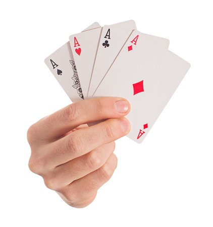 Close-up Of Hand Holding Four Aces On White Background