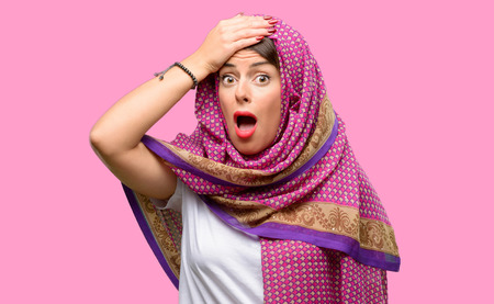 Young arab woman wearing hijab terrified and nervous expressing anxiety and panic gesture, overwhelmedの写真素材