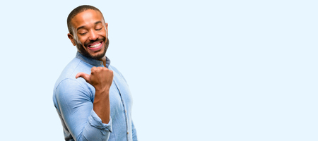 African american man with beard pointing away side with finger isolated over blue backgroundの写真素材
