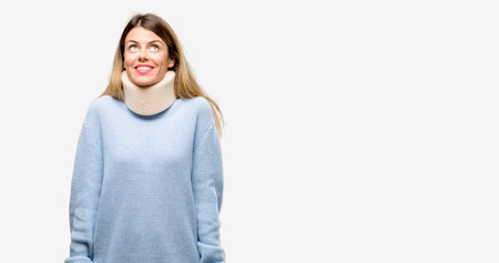 Young injured woman wearing neck brace collar thinking and looking up expressing doubt and wonderの写真素材