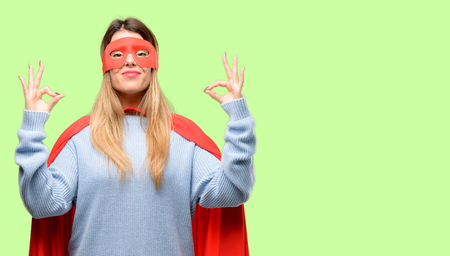 Young super woman doing ok sign gesture with both hands expressing meditation and relaxationの写真素材