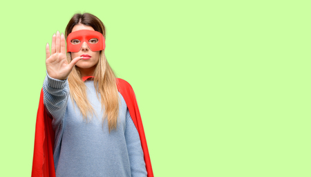 Young super woman annoyed with bad attitude making stop sign with hand, saying no, expressing security, defense or restriction, maybe pushingの写真素材