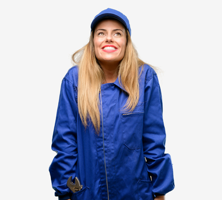 Young plumber woman thinking and looking up expressing doubt and wonderの写真素材