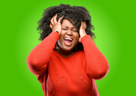 Beautiful african woman stressful keeping hands on head, terrified in panic, shoutingの写真素材