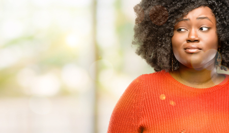 Beautiful african woman having skeptical and dissatisfied look expressing Distrust, skepticism and doubt, outdoorの写真素材