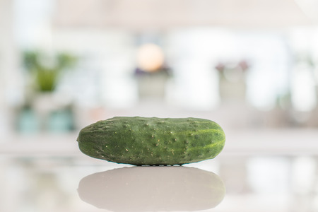 Closeup of cucumber on kitchen table with sunny bokeh background at home.の写真素材