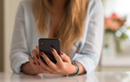 Woman using smartphone at homeの写真素材