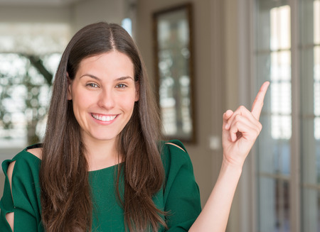Young beautiful woman at home very happy pointing with hand and finger to the sideの写真素材