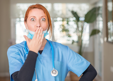 Medical professional woman with stethoscope cover mouth with hand shocked with shame for mistake, expression of fear, scared in silence, secret conceptの写真素材