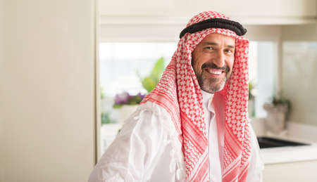 Middle age arabian man at home with a happy face standing and smiling with a confident smile showing teethの写真素材